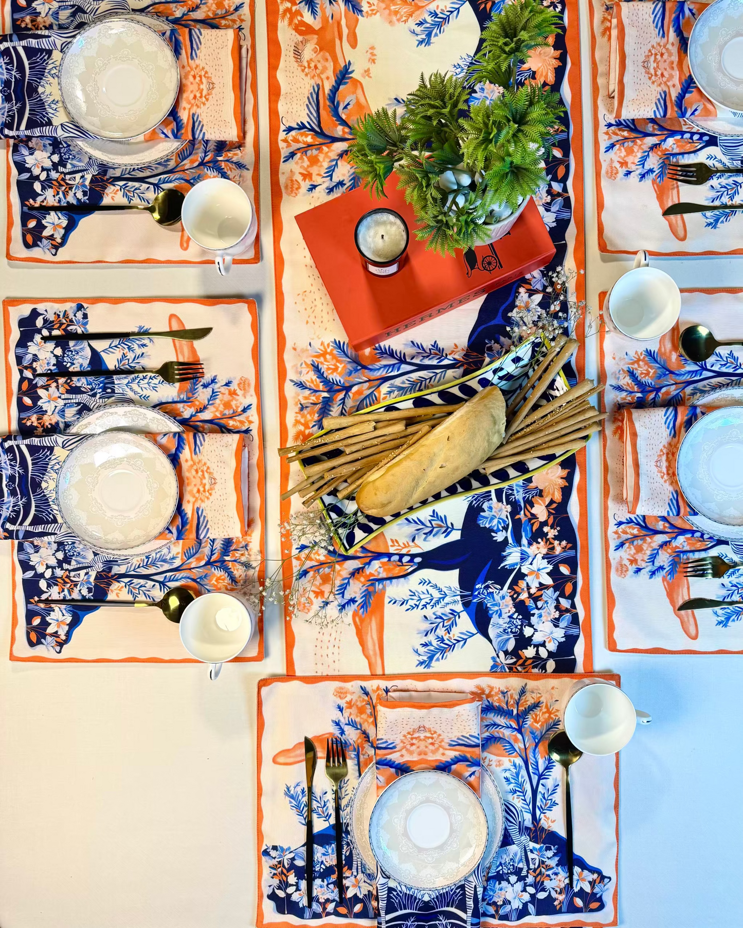 Decorative table setting with patterned placemats, plates, and cutlery on a neutral background.